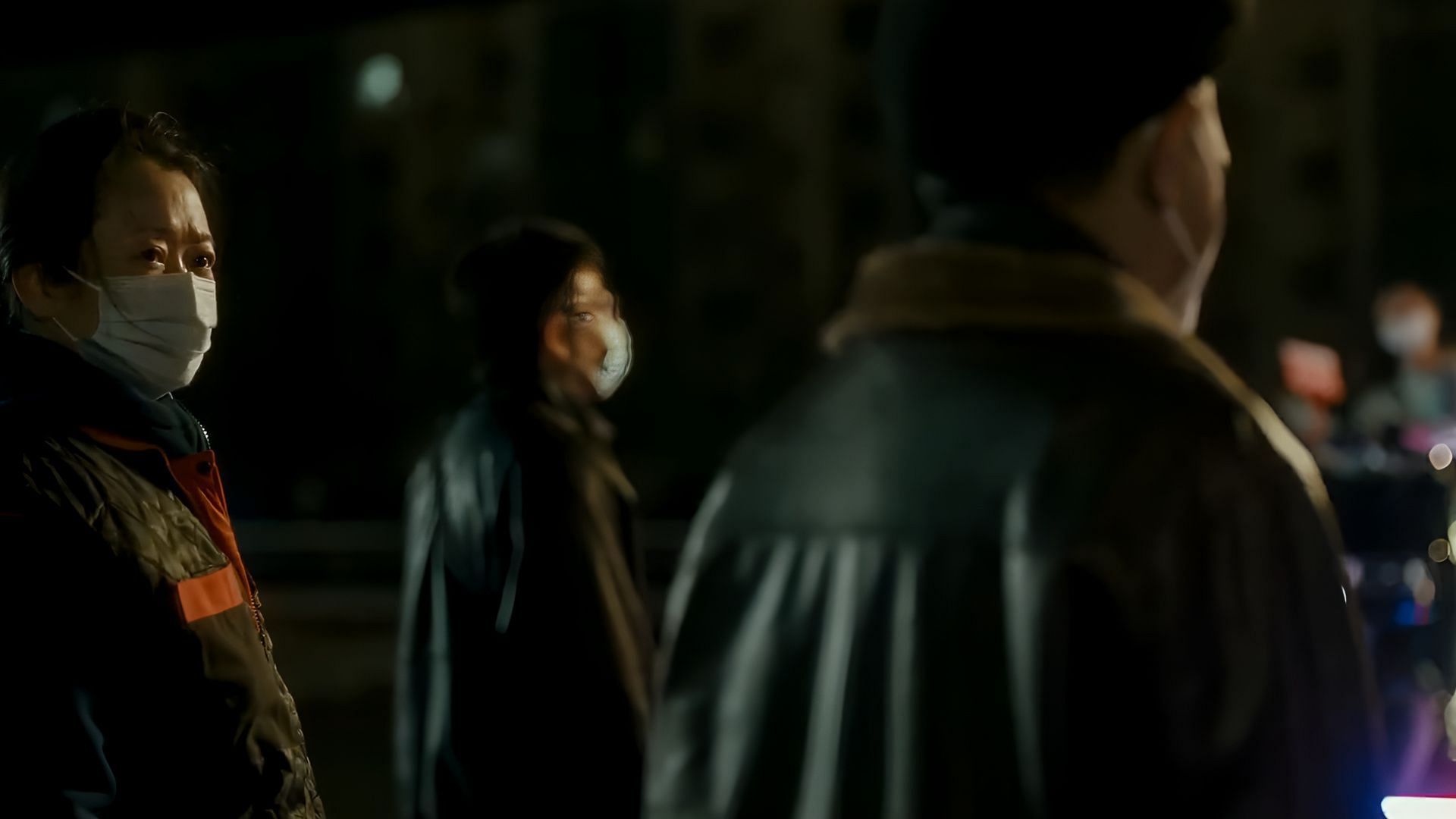 Qiaoqiao stands at a distance, masked and solemn, in a tense moment of confrontation with Bin in Caught by the Tides. (Image via International Film Festival Rotterdam)